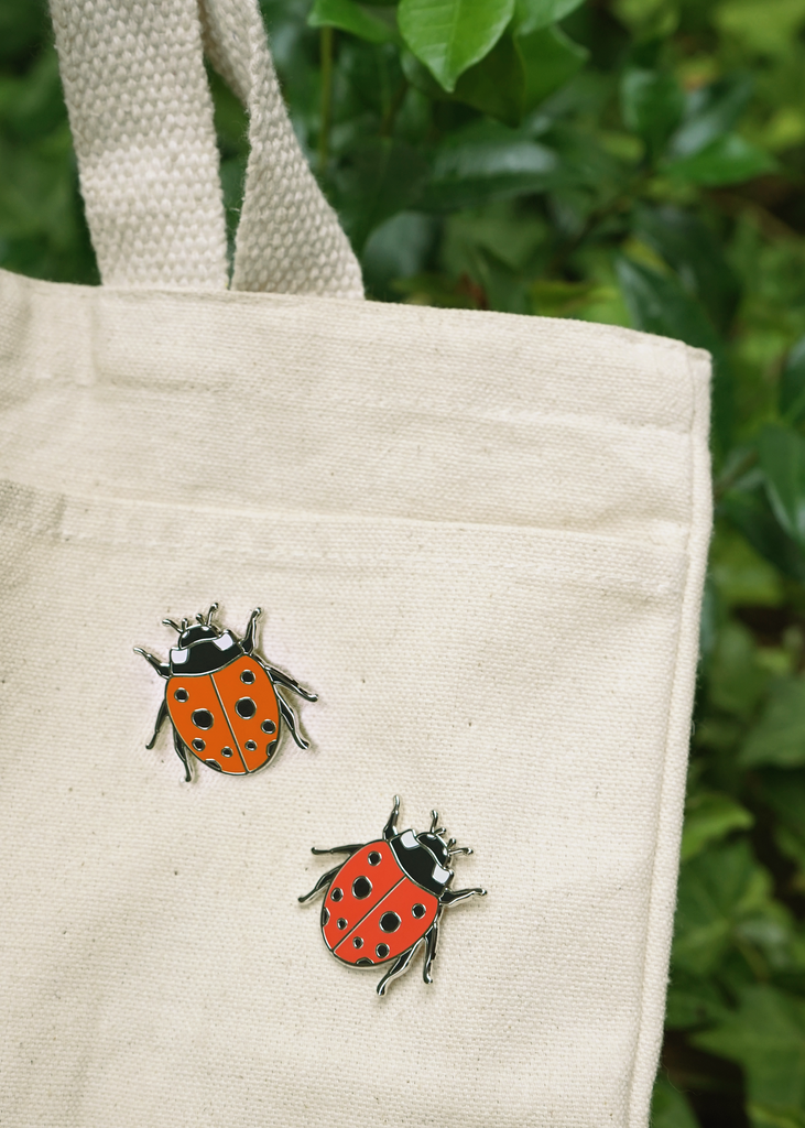 Red ladybug pins on canvas tote bag
