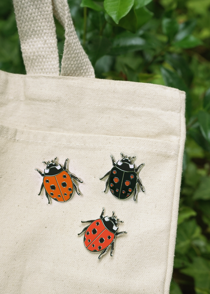Lady bug pin in black, tomato red, and cherry red on canvas tote bag