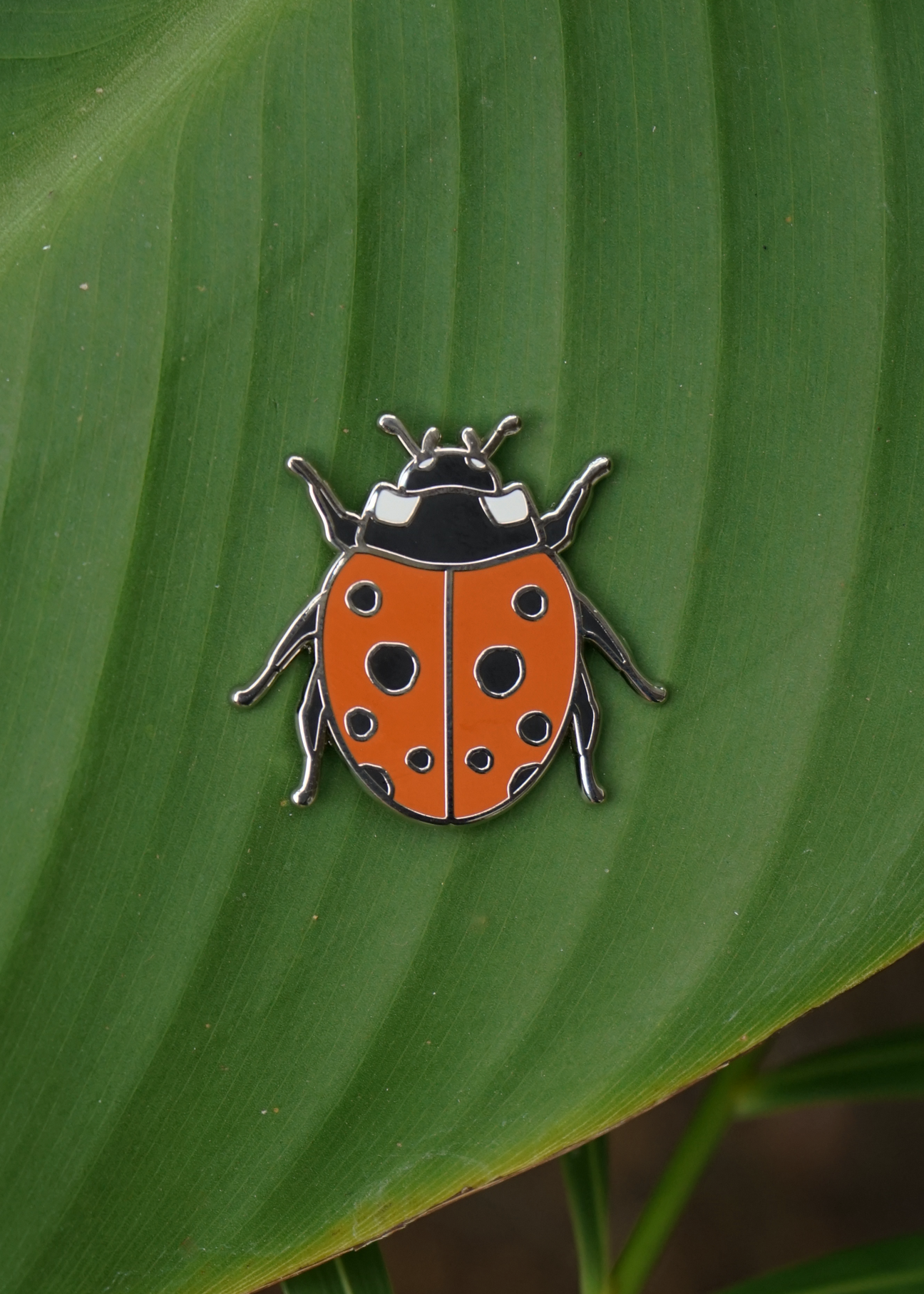 Tomato Red Ladybug pin on palm leaf