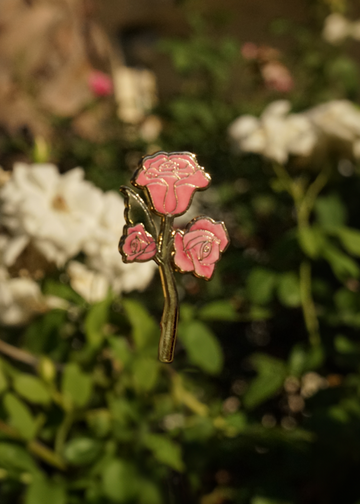 Pink rose pin against a floral background