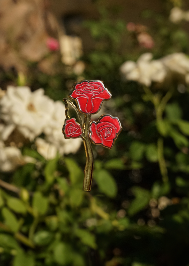 Red rose pin on a blurred floral background