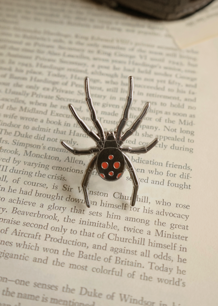 American Black widow pin on book page