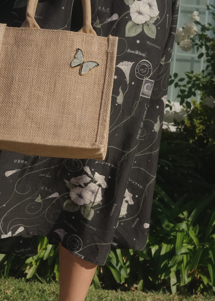 Model with mini tote bag decorated with white morpho pin