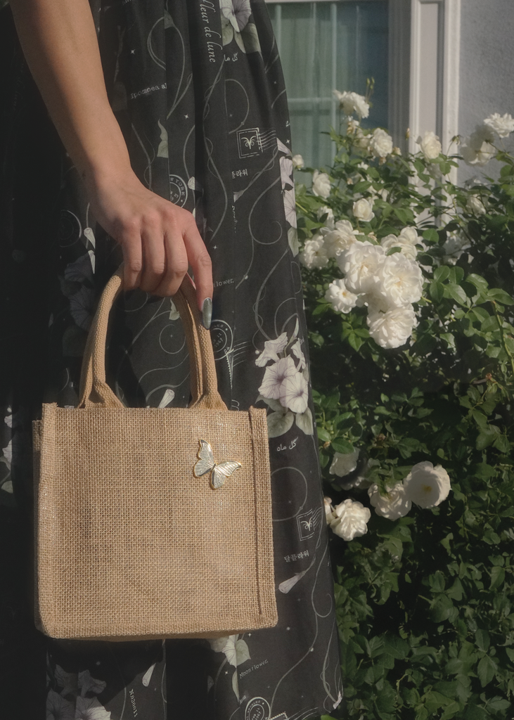 Model with mini tote bag decorated with white morpho pin