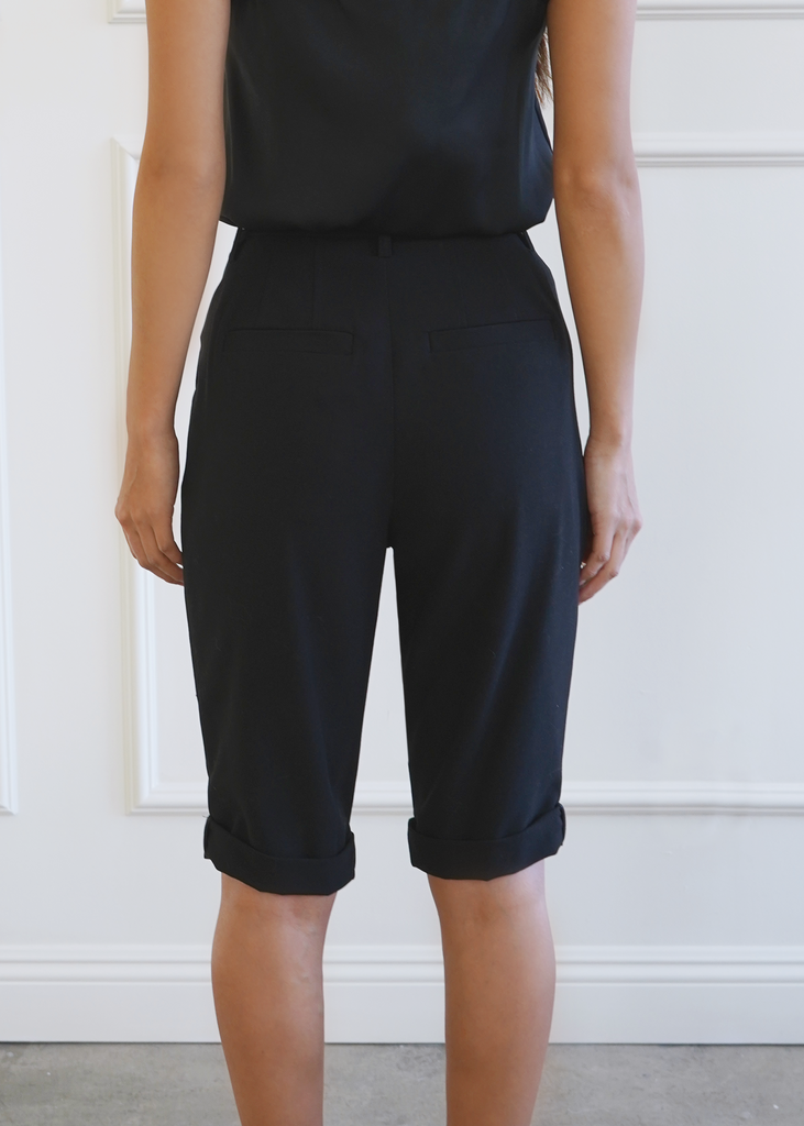 Back of mid length trousers with welt pockets and double darts