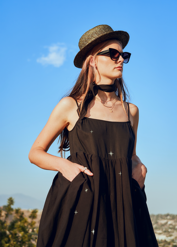 Model wearing Marili dress in black with silver embroidered stars