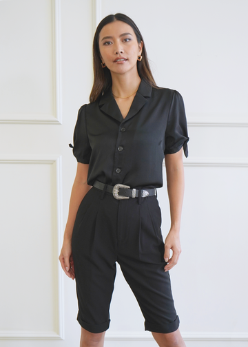 Front of model wearing knot sleeve black satin Atlas Shirt with notched collar tucked in