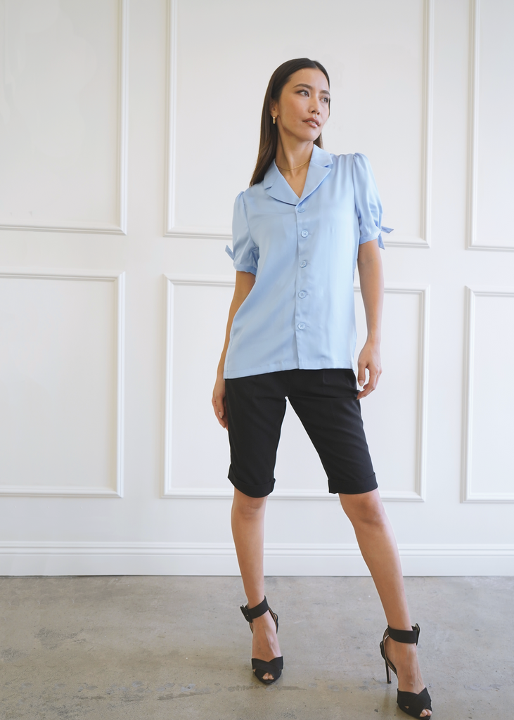 Front of model wearing satin serenity blue notched collar Atlas shirt with knot sleeves untucked