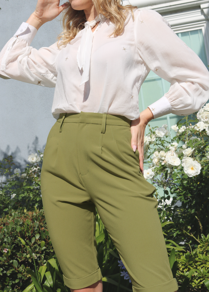 Close up of model wearing Andro mid length double pleated trousers in olive